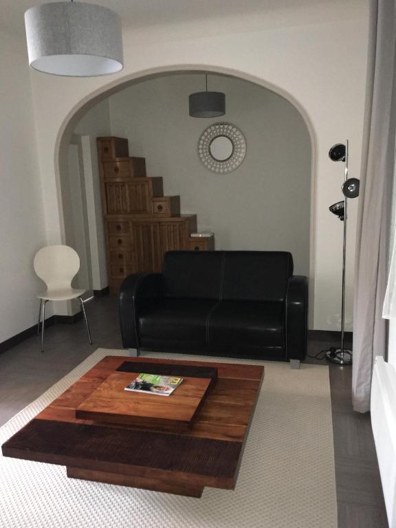 un salon avec un canapé noir et une table dans l'établissement Charmante maison au cœur du village, à Saint-Nicolas-de-Bourgueil