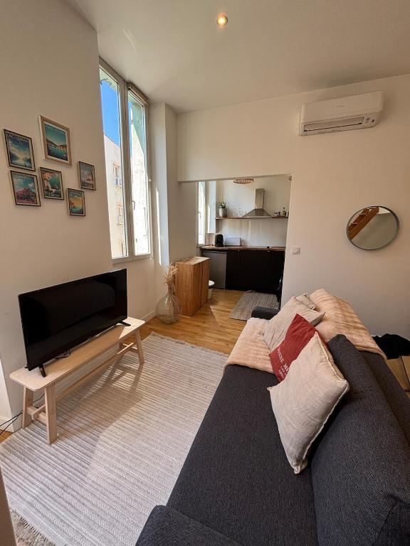 un salon avec un canapé et une télévision à écran plat dans l'établissement Le Carré D'Opéra, à Marseille