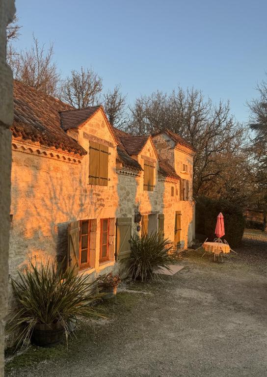 une ancienne maison en pierre avec quelques plantes devant elle dans l'établissement La Garenne, à Carnac-Rouffiac