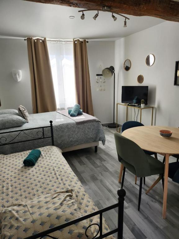 une chambre avec deux lits, une table et une salle à manger dans l'établissement Sleep'in Orléans centre-studio confortable et cosy, à Orléans