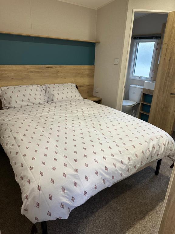 a bed with a white comforter in a bedroom at Silver Dunes in Lossiemouth