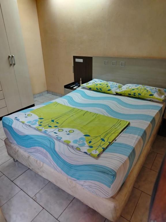 a large bed with a colorful blanket on it at Habitación en casa zona Asunción in Asunción