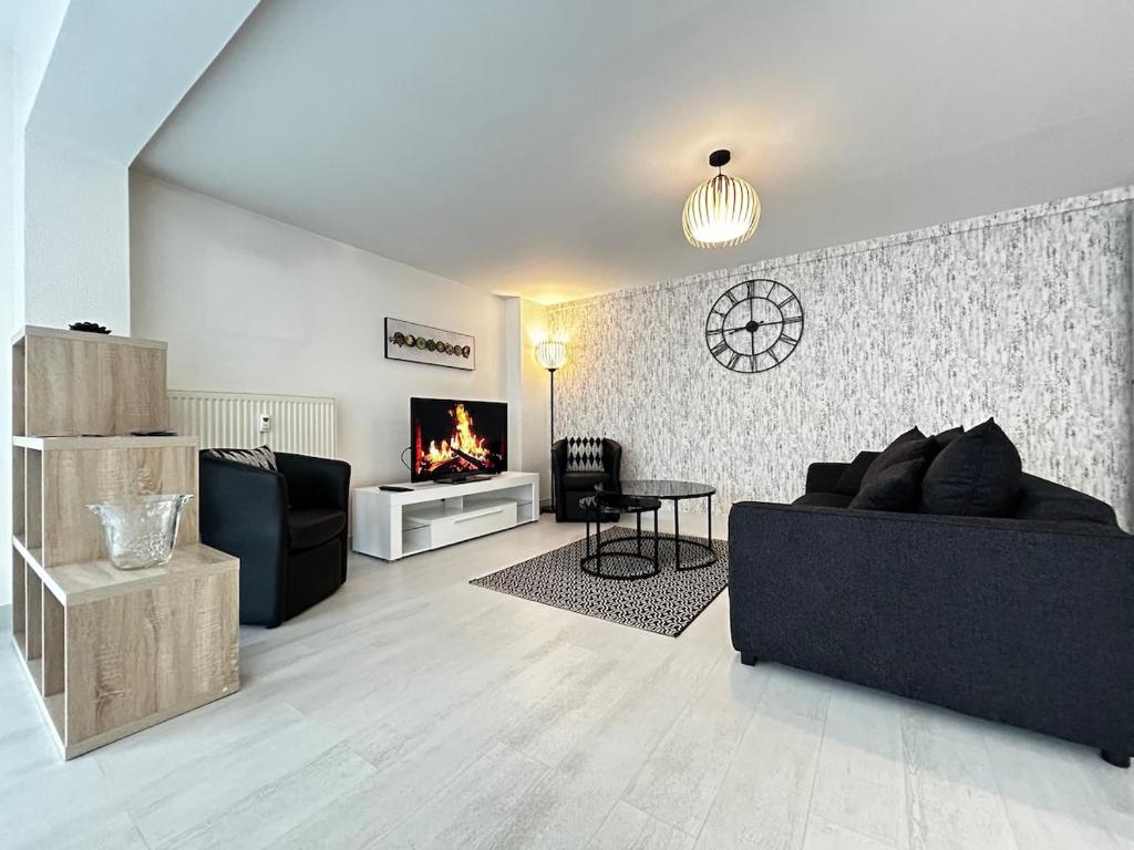un soggiorno con divano nero e camino di E Mercier magnifique grand T2 à deux pas du centre a Épernay