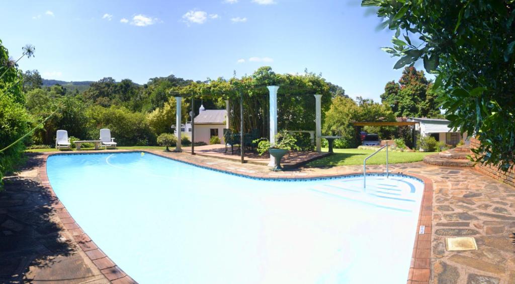 a swimming pool in a yard with a house at Brevisbrook B&B in Pietermaritzburg