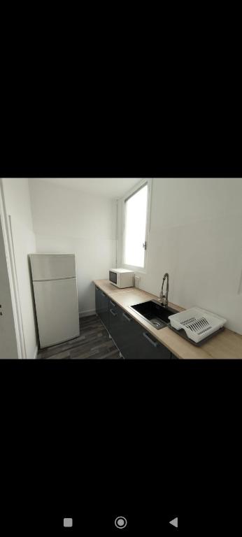 une petite cuisine avec un évier et une fenêtre dans l'établissement Superbe Appart 4 chambres Terrasse vue sur les Montagnes, à Saint-Paul-de-Fenouillet