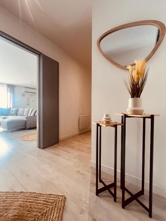 Cette chambre comprend une table et un miroir mural. dans l'établissement Le Félicité appartement spacieux avec parking, à Nîmes