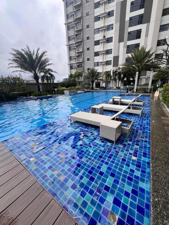 a large swimming pool with blue tiles in a building at Luxurious condo with City View in Horizons 101 in Cebu City