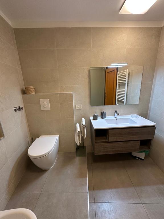 łazienka z umywalką, toaletą i lustrem w obiekcie B&B Martina w Taominie