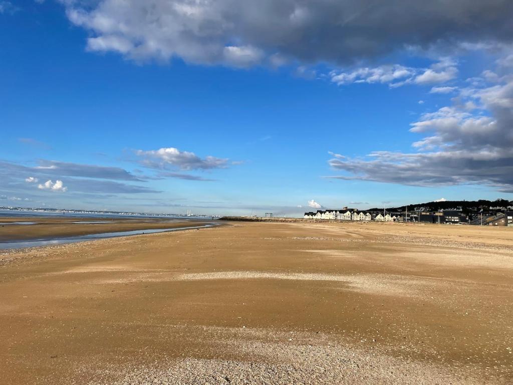 une plage vide avec un ciel bleu et des nuages dans l'établissement L ' Encre II, à Benerville-sur-Mer