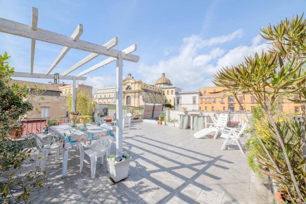 een terras met een tafel en stoelen op een dak bij Mimì Terrace in Napels