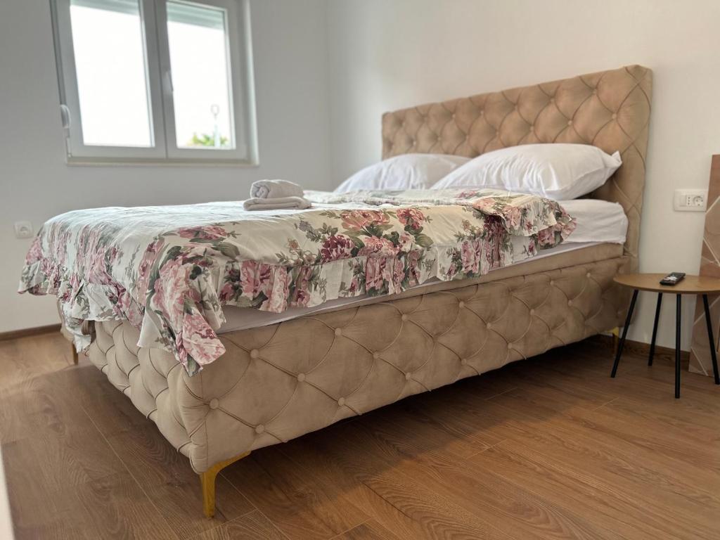 a bed with a floral bedspread on it in a bedroom at Medjugorje Apartments Centre in Međugorje