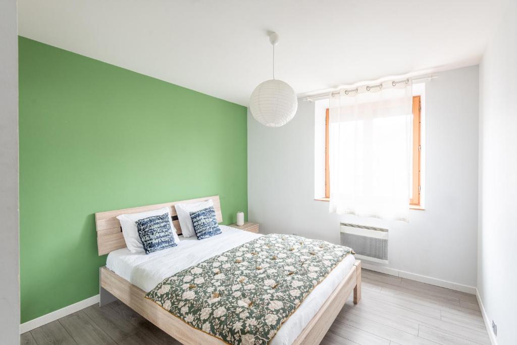 - une chambre avec un mur vert et un lit dans l'établissement M30 Marquer Agréable T2 centre ville, à Annemasse