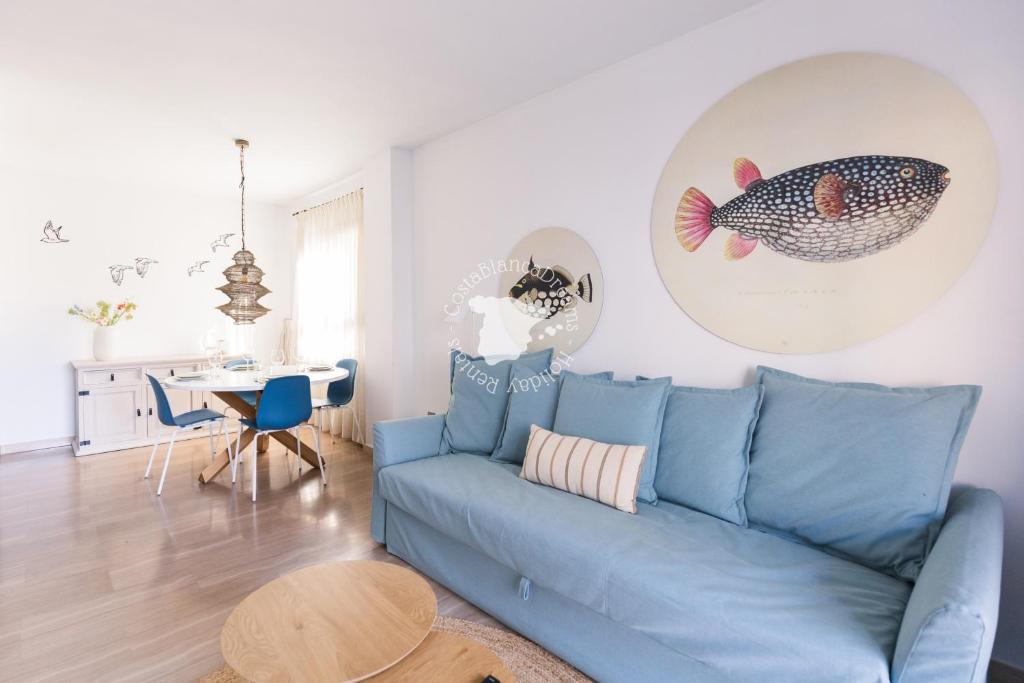 a living room with a blue couch and a table at Apartment El Sol in Moraira