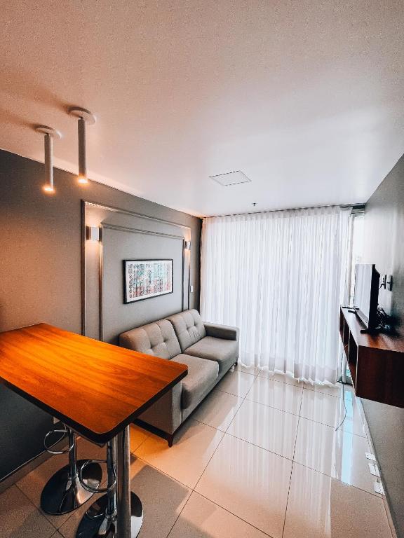 un salon avec un canapé et une table dans l'établissement DF PLAZA - Lindo apartamento com suíte!, à Brasilia