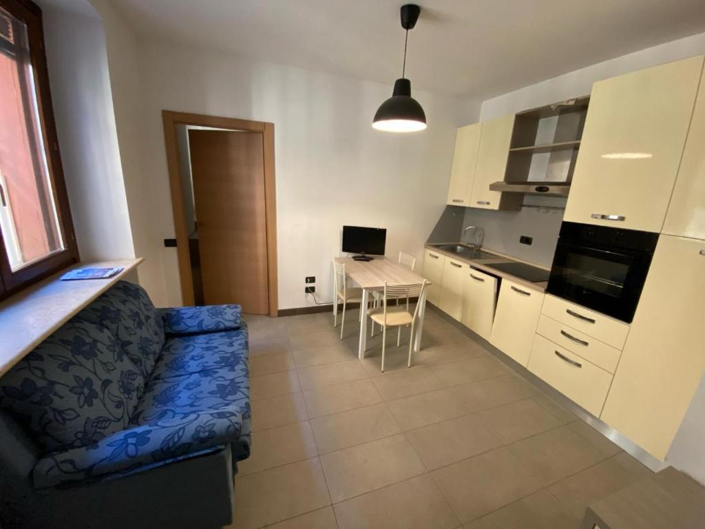 a kitchen and a living room with a couch and a table at Domus KA 3 in Cremona