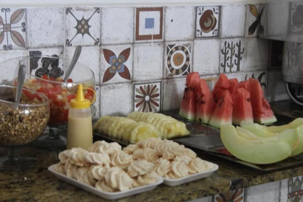 a kitchen counter with fruits and vegetables on a table at Hotel Prime Ceaka in Caruaru