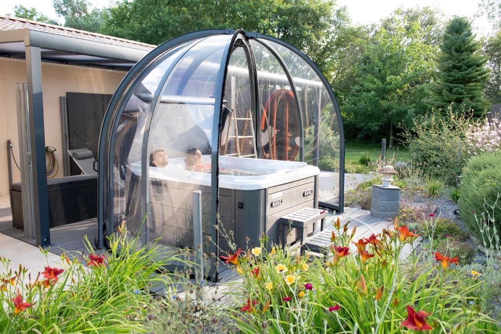 a baby in a bubble bath in a greenhouse in a garden at L'Escale Sud Gironde - Séjour en amoureux avec jacuzzi privatif - Piscine - Massage Traiteur & Brunch possibles in Pompéjac