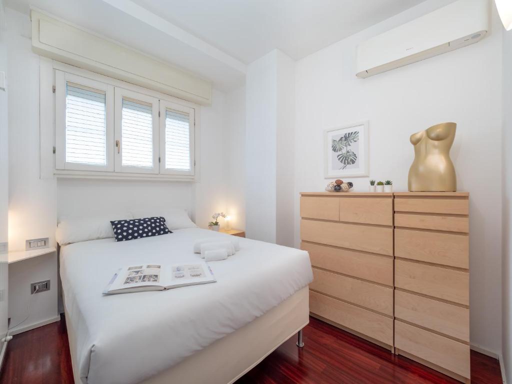 a white bedroom with a bed and a dresser at Residence Vigliani in Milan