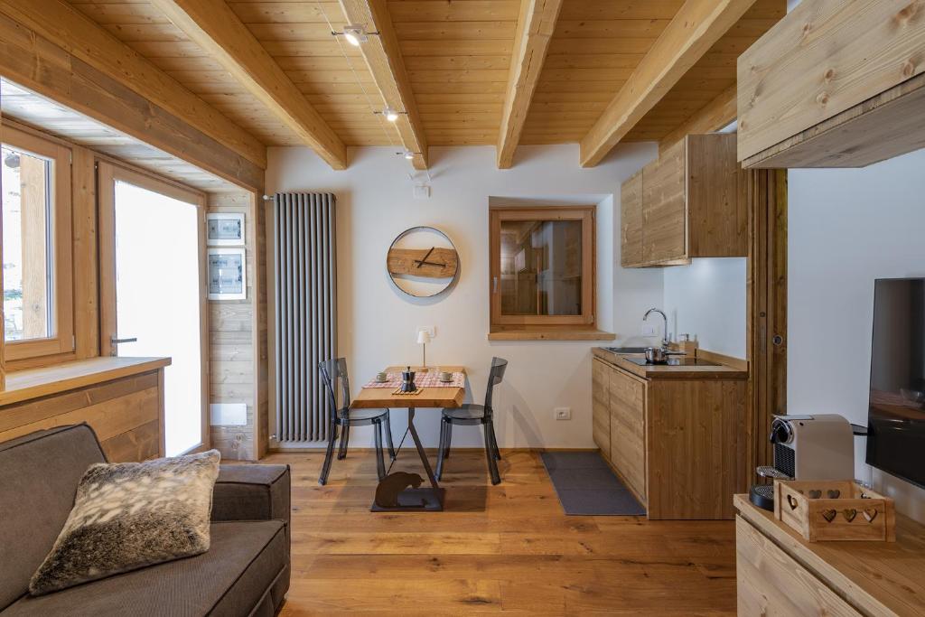 a living room with a table and a kitchen at Chalet la Mia Baita 2 - AffittiPontediLegno in Ponte di Legno
