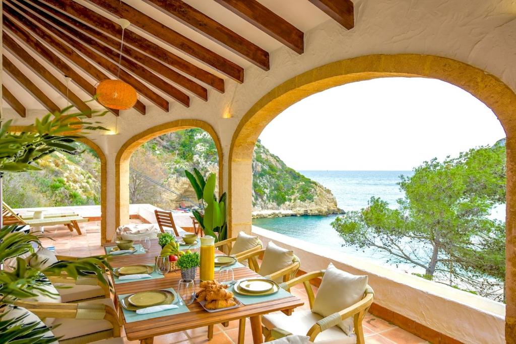 a dining room with a table and a view of the ocean at Breathtaking Sea Views, Cala Granadella, Free Parking in Jávea