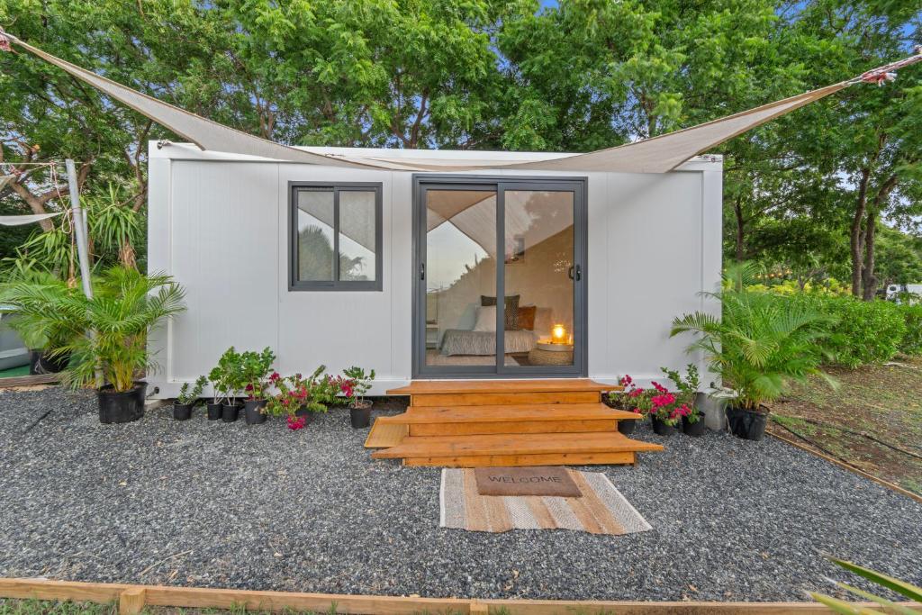 una casa pequeña con una pasarela de madera delante de ella en Green Cottage #1 Pitahaya, en Cabo Rojo