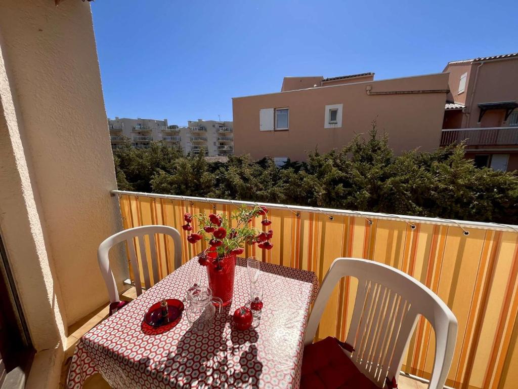 ein Tisch mit einer Vase mit Blumen auf einem Balkon in der Unterkunft Appartement T2 climatisé à Cavalaire, parking privé, proche centre et plages, balcon au calme - FR-1-226B-110 in Cavalaire-sur-Mer