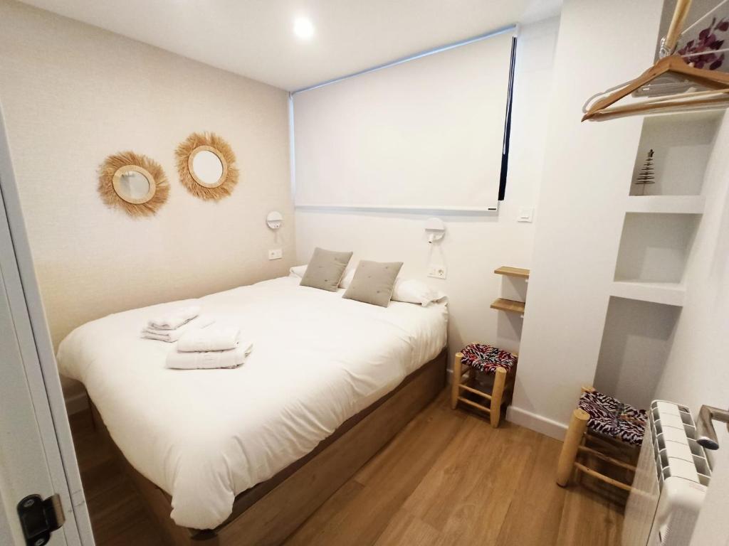 sypialnia z łóżkiem z białą pościelą i oknem w obiekcie IMEDA Apartamentos MONTE GORBEA w mieście Sierra Nevada