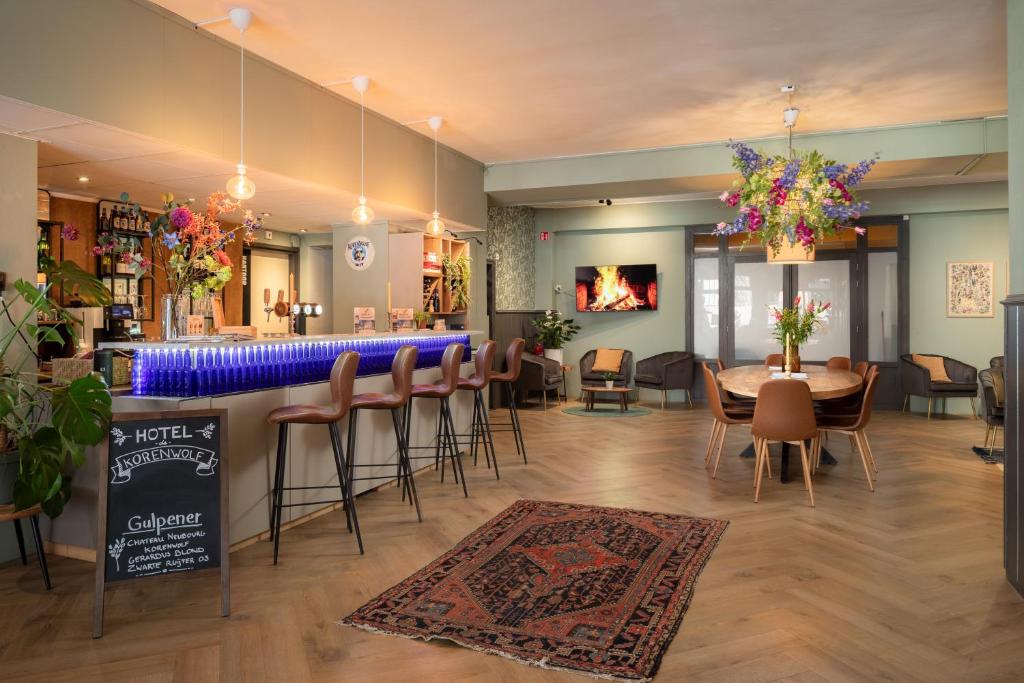 een restaurant met een bar en een tafel en stoelen bij Hotel de Korenwolf in Gulpen