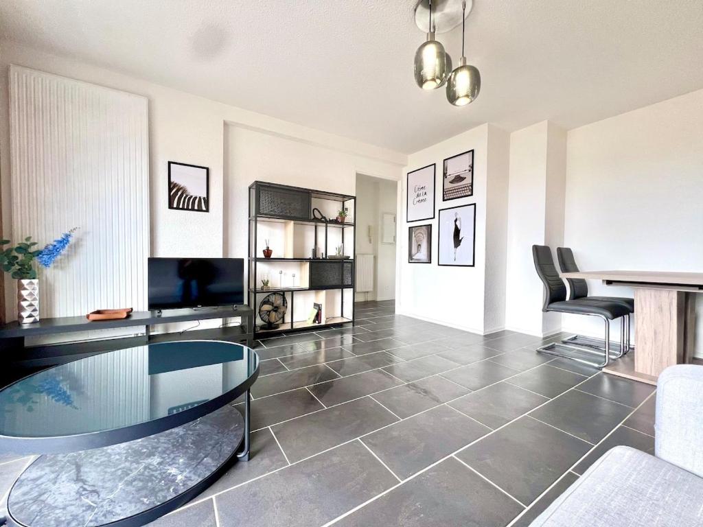 Una sala de estar con una mesa de cristal y sillas. en Le Silène T3 - 4 personnes, en Cluses