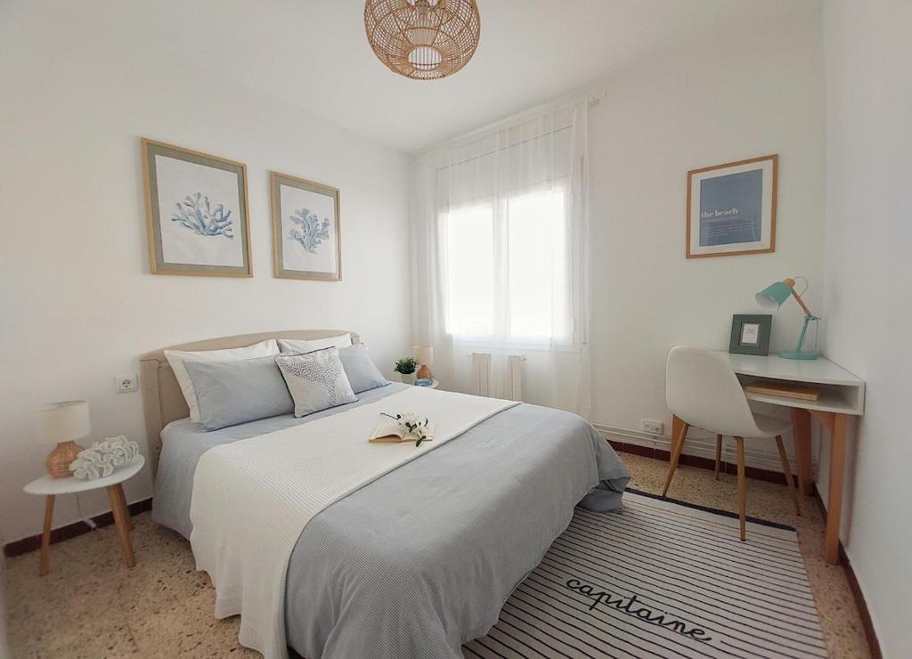 a bedroom with a bed and a desk and a window at Cozy beach apartment in Calafell