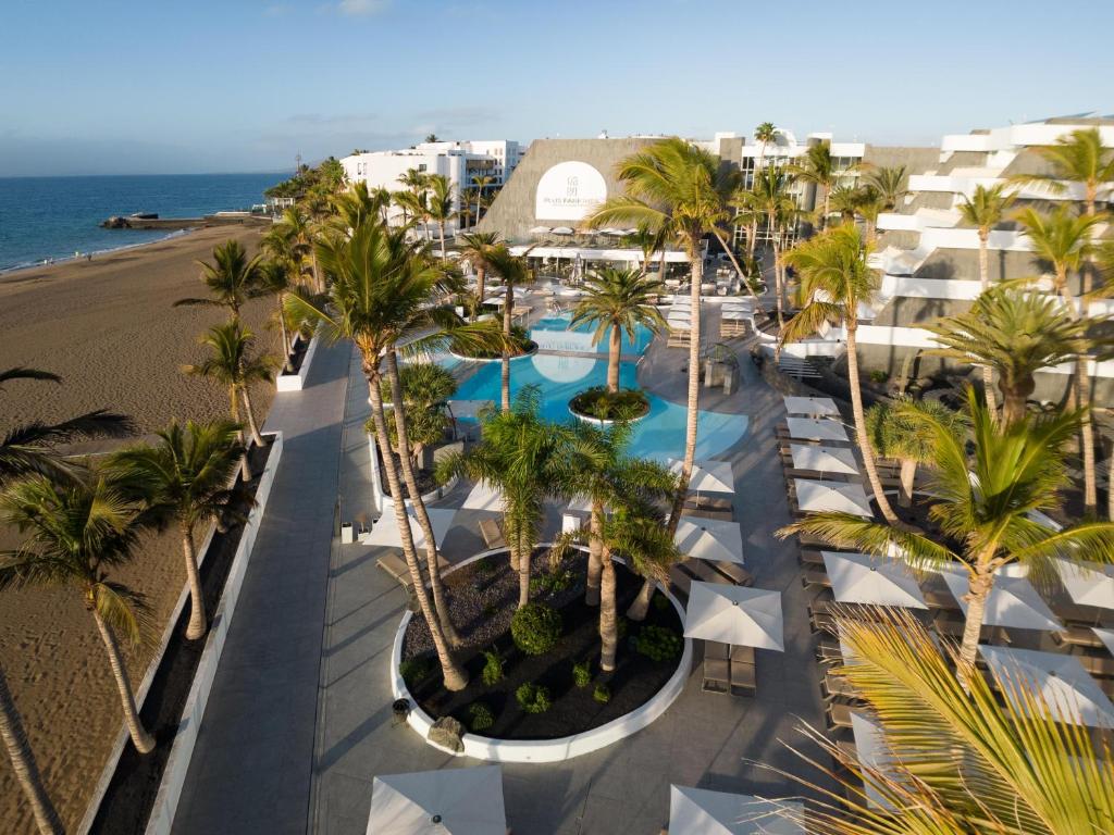 an aerial view of a resort with palm trees and a beach at Plus Fariones Suite Hotel in Puerto del Carmen