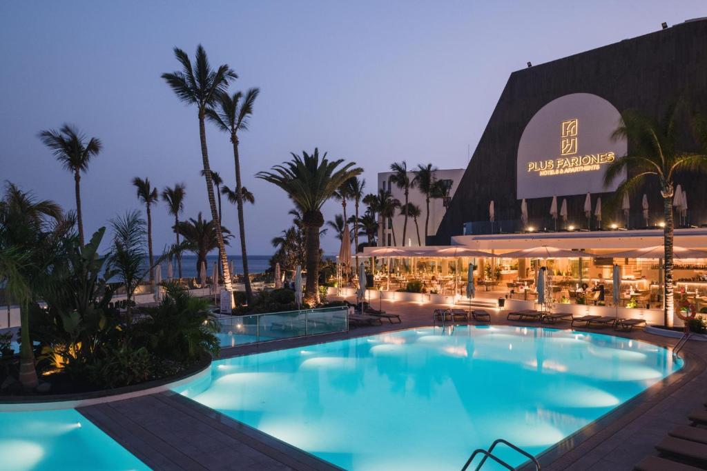 a large swimming pool in front of a hotel at Plus Fariones Suite Hotel in Puerto del Carmen