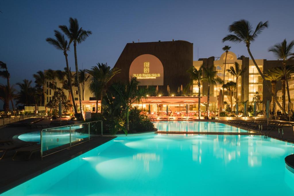 a swimming pool in front of a hotel at night at Plus Fariones Suite Hotel in Puerto del Carmen