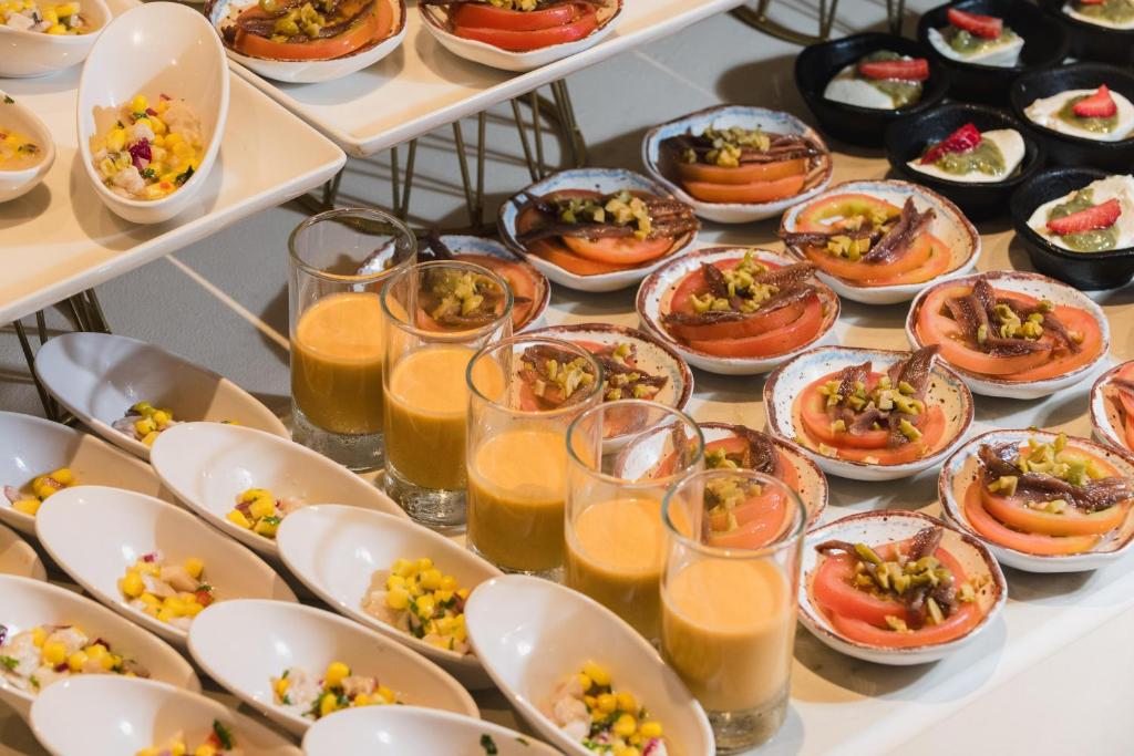 a buffet with plates of food and glasses of orange juice at Plus Fariones Suite Hotel in Puerto del Carmen