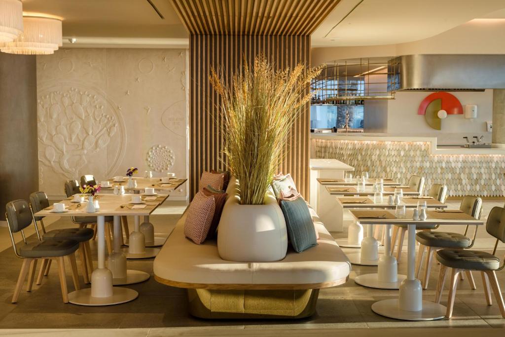 a restaurant with tables and chairs and a vase with plants at Plus Fariones Suite Hotel in Puerto del Carmen