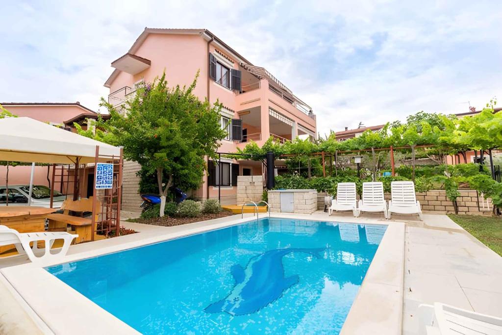 a swimming pool in front of a house at Apartment Pula, Istria 18 in Veli Vrh