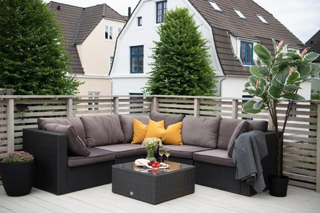 een bank op een patio met een tafel bij Spacious apt, Big roof terrace, Free parking in Stavanger