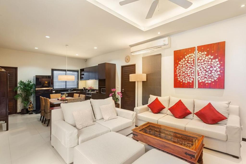 a living room with a white couch and red pillows at Villa Anatta for your serene vacation in Ban Saiyuan (1)
