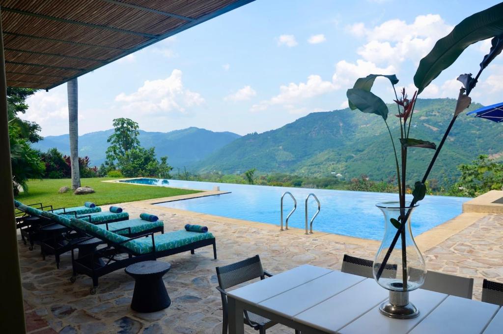 a view of a pool with chairs and a table at Villa en Club Campestre Mesa de Yeguas in Anapoima