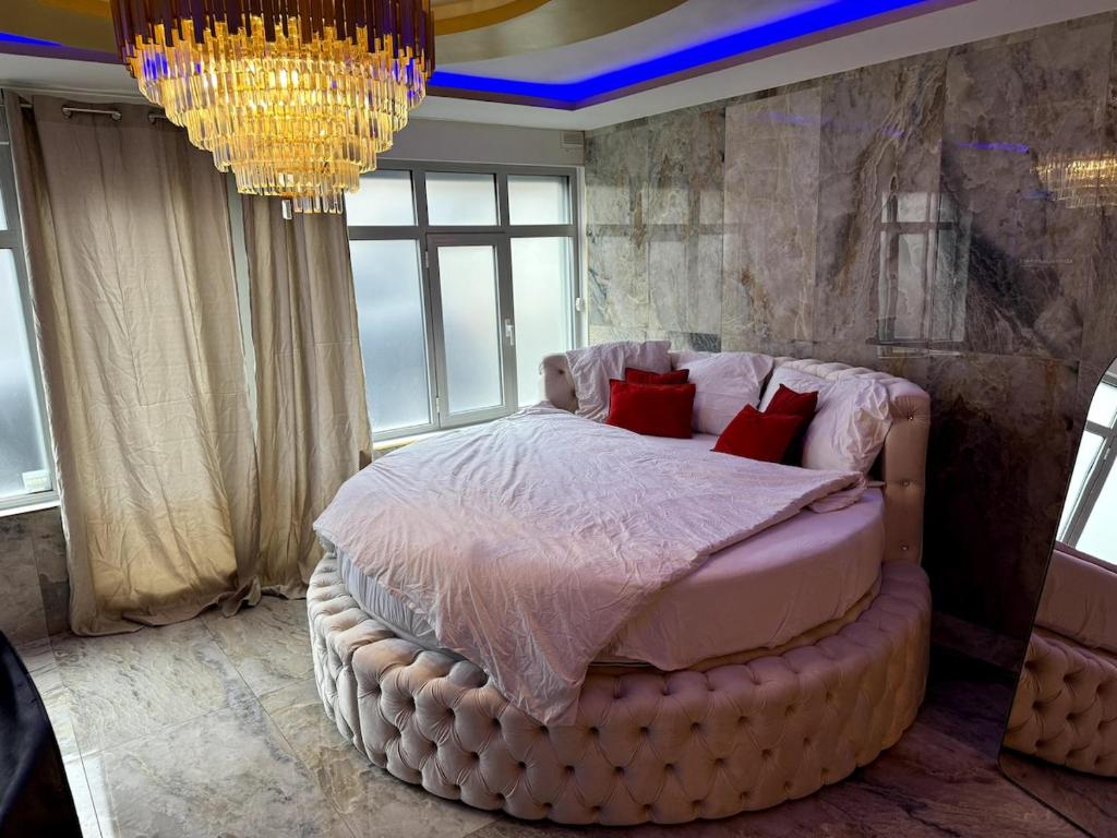 une chambre avec un grand lit avec des oreillers rouges dans l'établissement Golden house 2 - Jacuzzi, à Rouen