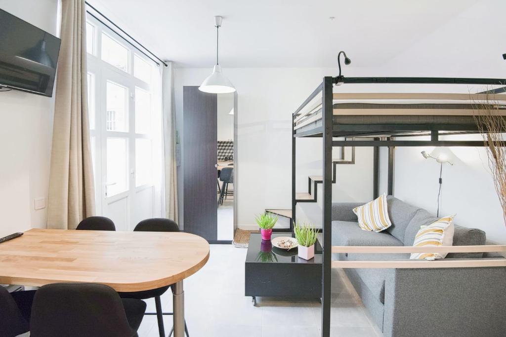 - un salon avec une table et une mezzanine dans l'établissement Charming Studio Steps Away from Montmartre, à Paris