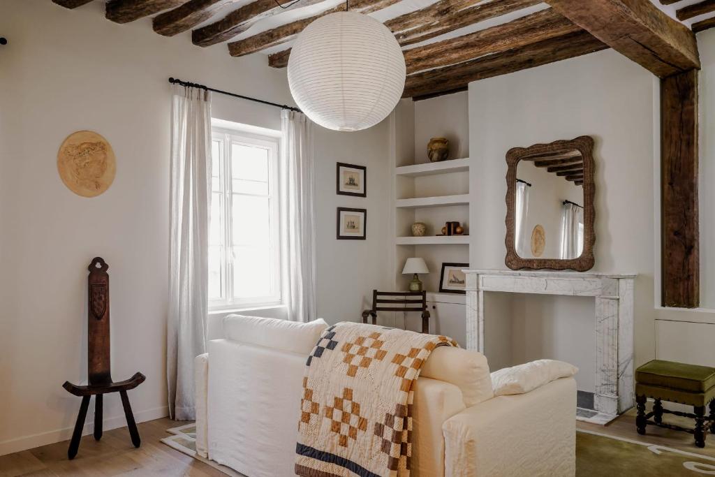 - un salon avec un canapé blanc et un miroir dans l'établissement Appartement de charme dans le centre de Rouen, à Rouen