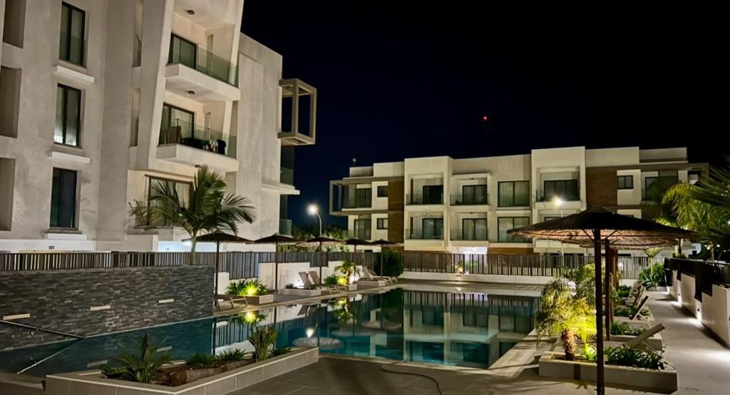 a hotel with a swimming pool at night at Cosmos Residence in Paralimni