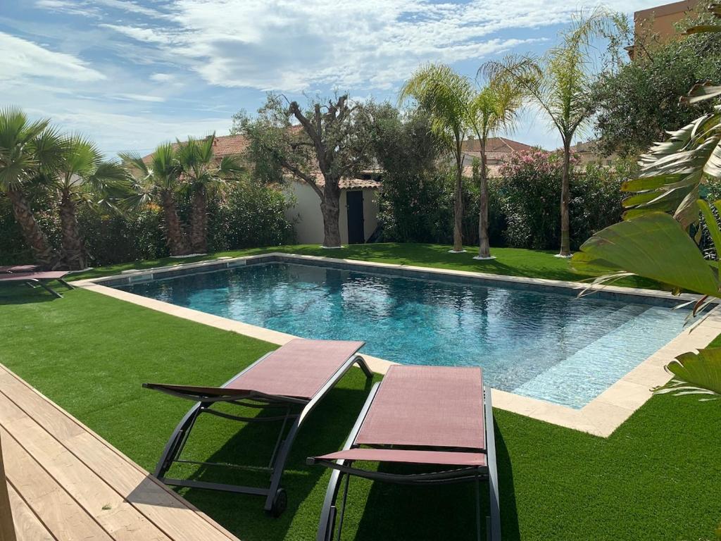 une piscine avec deux chaises et une table dans l'établissement Villa Mona 