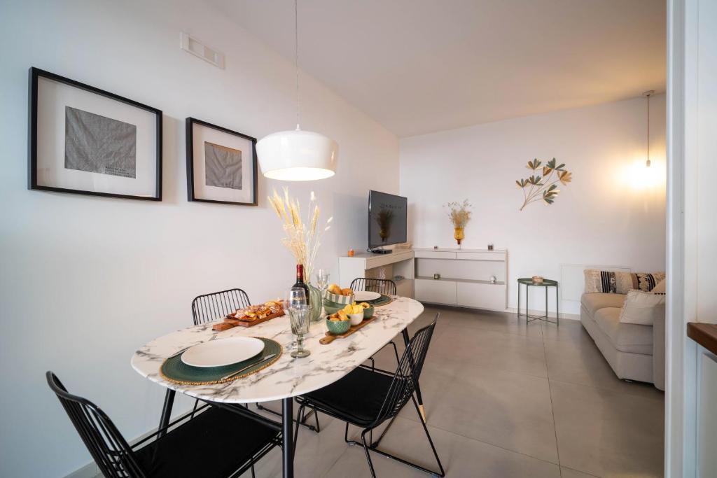 a dining room and living room with a table and chairs at Opuntia Home in Monopoli