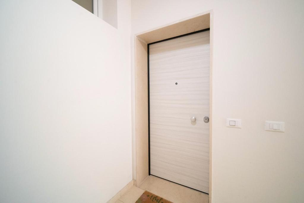 a white garage door in a white room at Opuntia Home in Monopoli