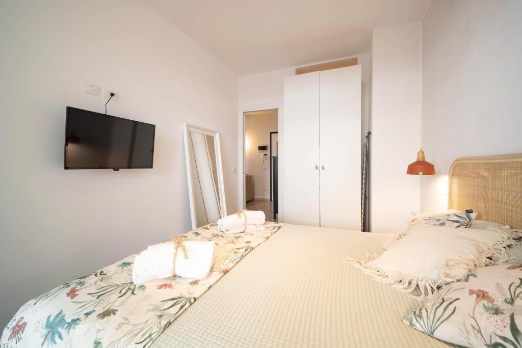 a bedroom with a bed with a tv on the wall at Opuntia Home in Monopoli