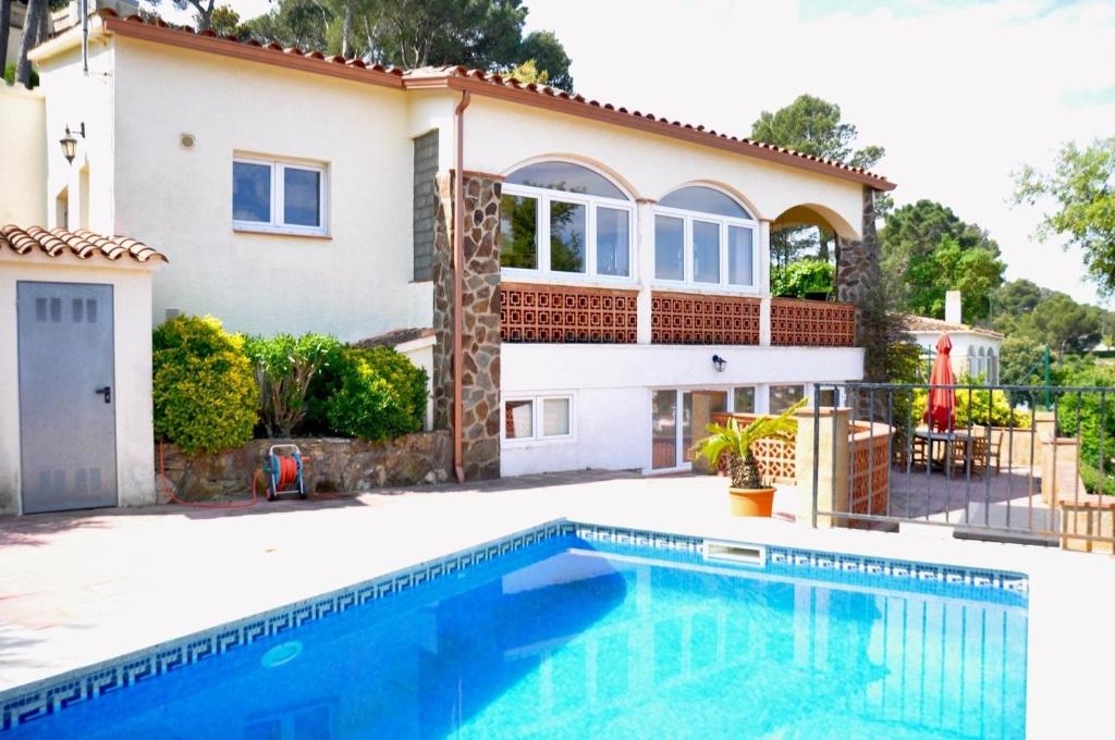 a house with a swimming pool in front of it at Casa Mas Tomasi Pals in Pals