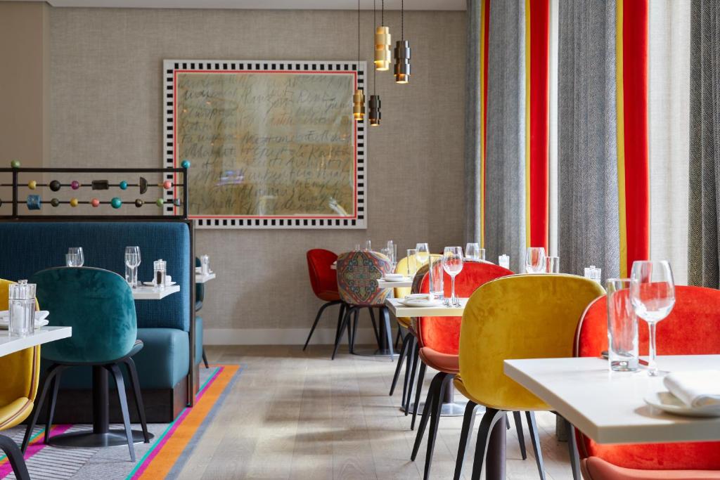 a restaurant with tables and chairs and a painting on the wall at Rudding Park in Harrogate