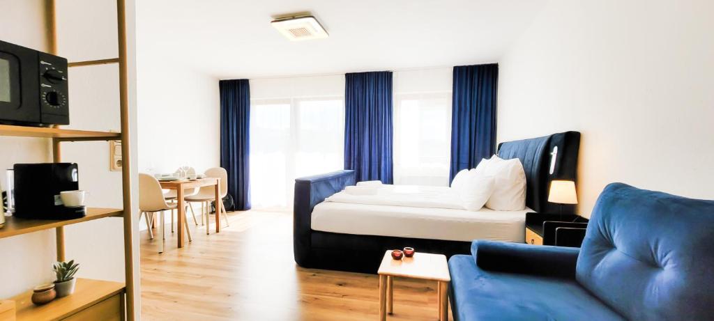 a room with a bed and a couch and a table at KOMM - Panoramablick - Balkon - Küche - Parkplatz in Suhl